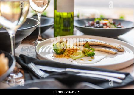 Dorado or sea bass fillet in cream sauce with broccoli on a white plate. High quality photo Stock Photo