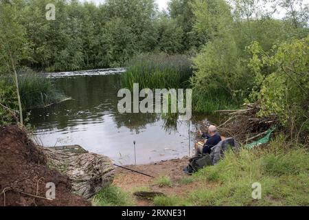 Man fishing with rod and line in quiet spot River Avon near Evesham UK Stock Photo