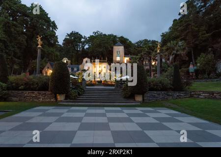 Portmeirion village chessboard square with illuminated Italian-style buildings at dusk Stock Photo