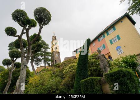 Colourful Italianate buildings and bell tower in Portmeirion village with topiary trees Stock Photo