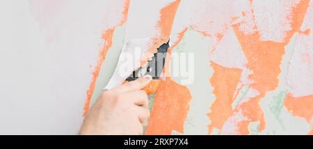 Male using spatula and plastering of wall with white fresh finishing putty banner copy space. Closeup. Repair work of home. Side view. Stock Photo