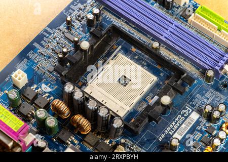 Old GigaByte motherboard with an empty CPU socket, no processor installed GA K8 NE-RH model, dusty computer components e-waste technology, old hardwar Stock Photo