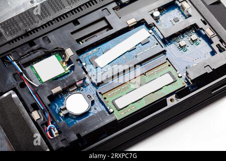 Opened modern laptop with back cover off being repaired, serviced, RAM sticks on the motherboard detail closeup, laptop internal components parts conc Stock Photo