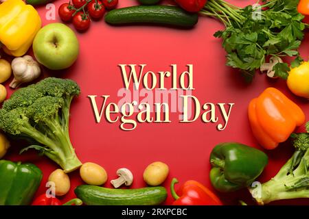 Greeting card for World Vegan Day with many vegetables on red background Stock Photo