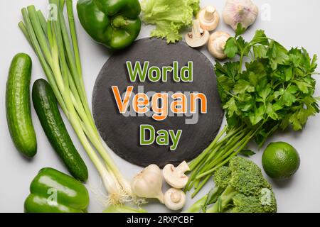 Greeting card for World Vegan Day with many vegetables on light background Stock Photo