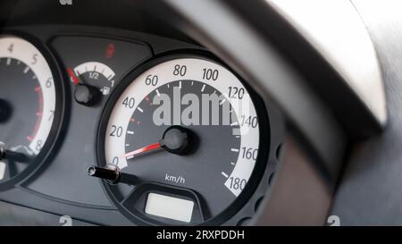 Speedometer in a simple generic motionless stopped car interior object detail closeup, showing speed in kilometers per hour, kmh unit, 0 to 180 speed Stock Photo