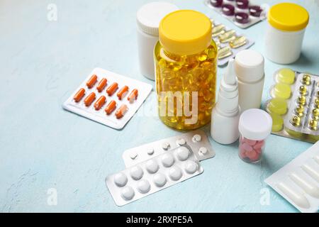 Different pills and bottles of medicines on light blue background Stock Photo
