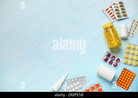 Different pills and bottles of medicines on light blue background Stock Photo