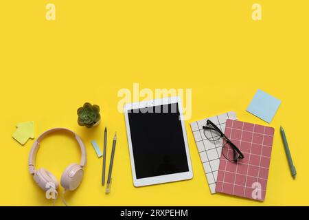 Tablet, notebooks and stationery on yellow background Stock Photo