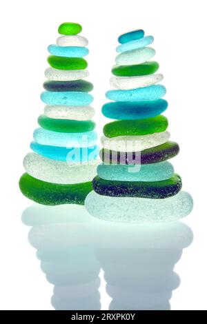 Two zen pyramids of balanced colored glass stones isolated on white background. Shards of glass bottles polished by sea waves Stock Photo