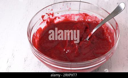 Bowl of fresh cooked homemade cranberry sauce close-up in a bowl on kitchen table. Stock Photo