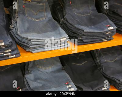 Jeans Folded and Displayed on Shelves in Retail Store Stock Photo