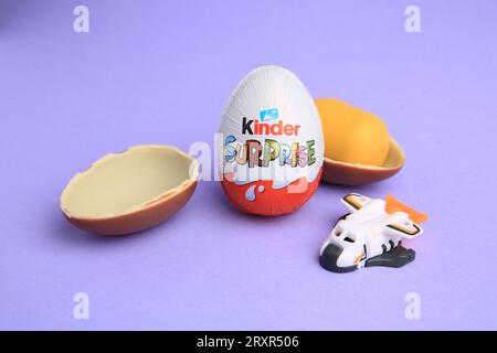 Sveti Vlas, Bulgaria - June 30, 2023: Kinder Surprise Eggs, plastic capsule and toy on violet background Stock Photo