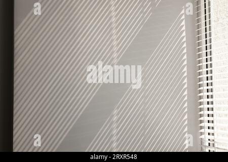 Shadow from window and blinds on beige wall indoors Stock Photo