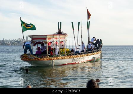Salvador, Bahia, Brazil - December 31, 2021: The Galiota boat is seen leaving the beach with the statue of Jesus Christ, the lord of sailors, in the c Stock Photo