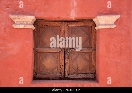 Wooden rustic window on red building wall Stock Photo