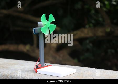 Small fan made out of dc motor and propeller is powered by a battery. Science project concepts Stock Photo