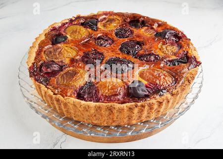 Plum pie with cinnamon, on white background ontransparent dish. Stock Photo