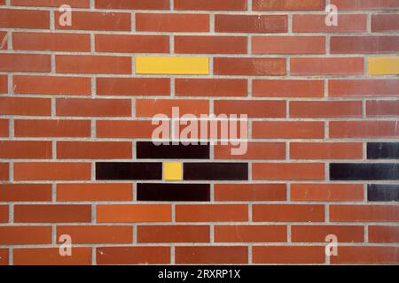 line red brick wall with black and yellow wall stone facade background of bricks horizontal stones wallpaper Stock Photo