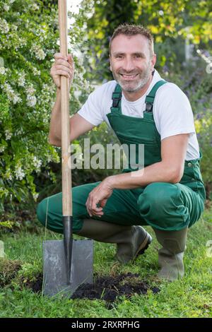 Young brunette man posing with a shovel Stock Photo - Alamy