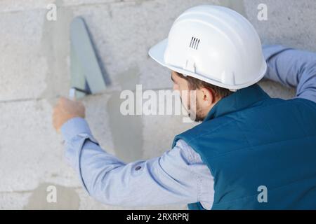 a tecnician plastering exterior wall Stock Photo
