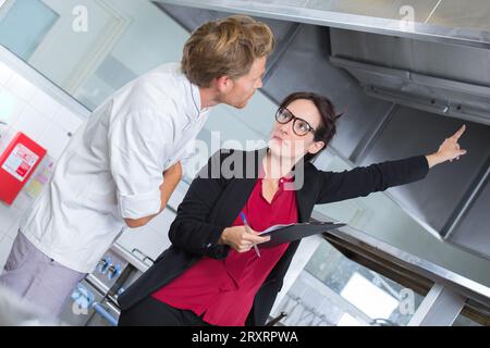 supervisor pointing at problem in the kitchen Stock Photo