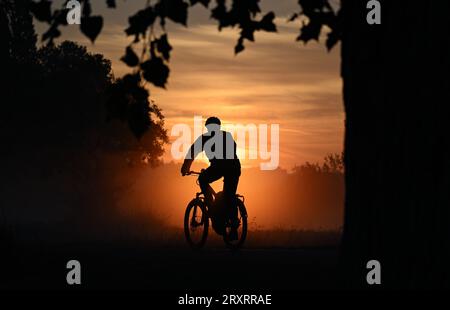 Dresden, Germany. 27th Sep, 2023. A cyclist is on the Elbe cycle path near the Ferry Garden in the morning during sunrise. Credit: Robert Michael/dpa/Alamy Live News Stock Photo
