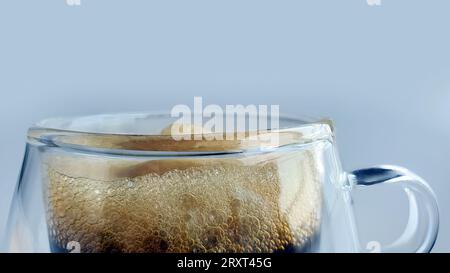 Close up black coffee with natural foam in double walled transparent glass with plain background, morning boost, espresso, americano, dark roasted, ro Stock Photo