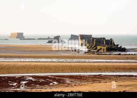 Remains of Phoenix caissons on the sand, used to build the Mulberry harbor on Gold Beach in Arromanches, France, after the Normandy landings in WWII. Stock Photo