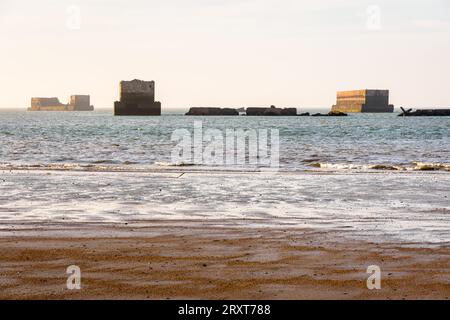 Remains of Phoenix caissons used to build the artificial Mulberry harbour on Gold Beach in Arromanches, France, after the Normandy landings in WWII. Stock Photo