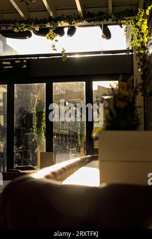 London, United Kingdom - January 15 2023: A dim interior of a London restaurant with bright light shining through the windows Stock Photo