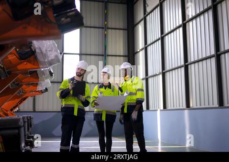 Engineer work at robotic arm factory. Technology and engineering concept. Stock Photo
