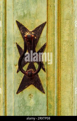 Traditional brass door knocker detail with Maltese cross design outside a building in the alleys of the old city of Birgu (Citta Vittoriosa), Malta Stock Photo