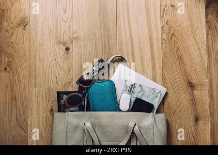 Travel Essentials Pack For Trip, Things Pack In Carry-On. Packing list for Airplane Tote. Female Carry-On luggage tote bag with laptop, notepad Stock Photo