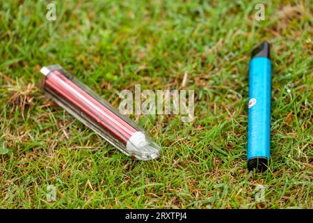 disposable single use vapes lying discarded on grass Stock Photo