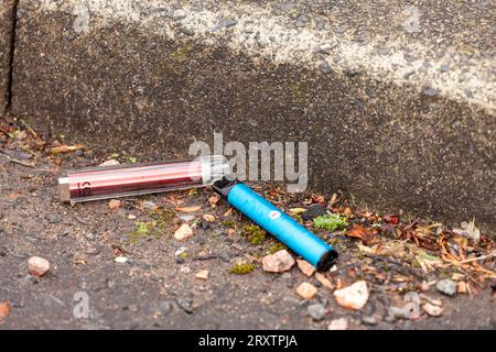 Single use disposable vapes lying discarded in the road Stock Photo