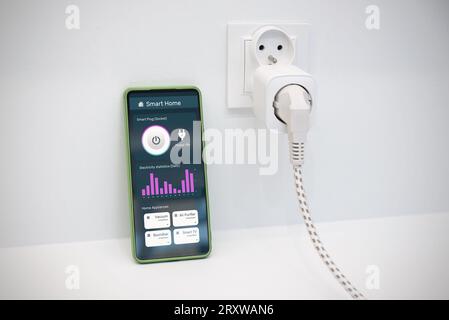 Using Wi-fi smart socket on the wall in a smart home, controlling electricity consumption Stock Photo