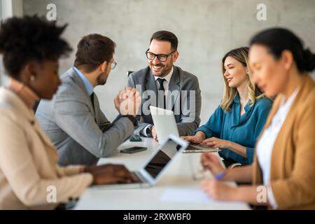 Multicultural professional businesspeople working together on research plan in boardroom. Stock Photo