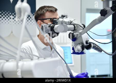 doctor in black mask using dental microscope in clinic. close up Stock Photo