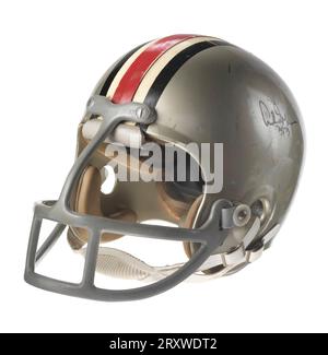 An Ohio State Buckeyes football helmet worn by Archie Griffin.  The hard plastic helmet is gray with black, white, and red lines running vertically from the front to the back in the middle of the helmet. There are holes throughout the surface of the helmet. The inside of the helmet has thick black padding. Grey plastic-coated metal bars form a face mask. The face mask juts out severely from the front of the helmet. It has one vertical bar down the center and two curved horizontal bars with additional bars between the horizontal bars into three sections. There is a white leather chin strap, sna Stock Photo