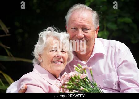 Happily married senior couple posing in front of the camera - John Gollop Stock Photo
