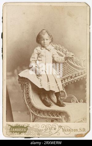 Photograph of a toddler standing on a wicker chair late 19th century Stock Photo