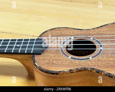 Close up of a soprano ukulele on a wooden surface. Stock Photo