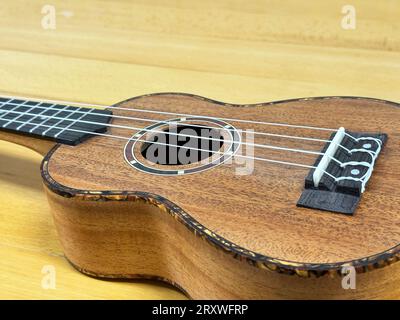 Close up of a soprano ukulele on a wooden surface. Stock Photo