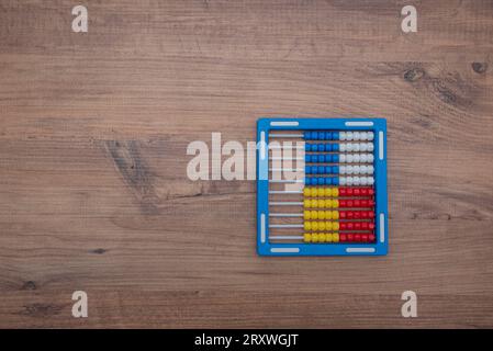 Childrens plastic abacus of blue color on a wooden surface. top view. flatlay. colorful abacus Stock Photo