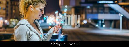 Young blonde sportswoman checking exercise progress on tracker mobile phone application Stock Photo