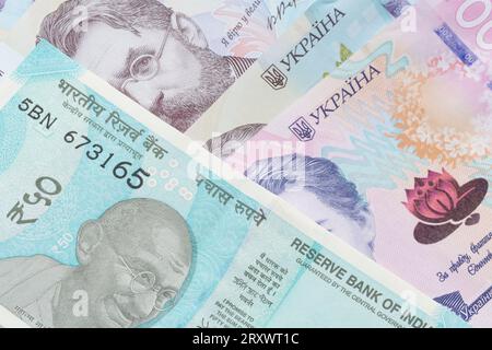 close up of fifty Indian rupee banknote lying on Ukrainian hrivnya banknotes Stock Photo