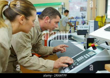 man and woman operating with a machine Stock Photo