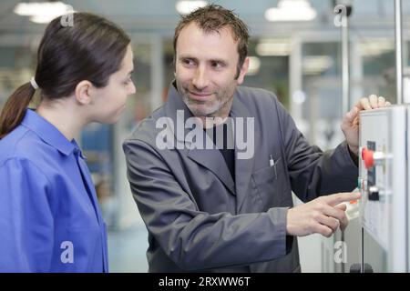 two technician wearing overall wrapped up in adjusting modern equipment Stock Photo