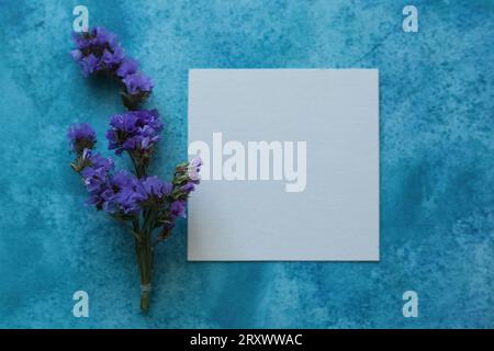 Limonium sinuatum, commonly known as wavyleaf sea lavender, statice, sea lavender, notch leaf marsh rosemary, sea pink flowers on a blue watercolor ba Stock Photo